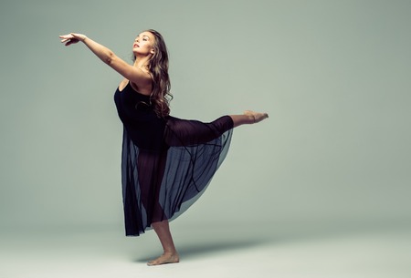 Woman in dance studio beautiful. Studio shot. Gray background.の写真素材