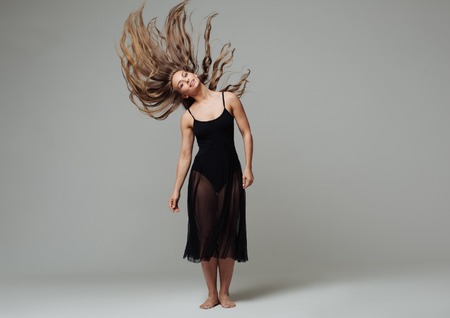 Woman in dance studio beautiful. Studio shot. Gray background.の写真素材