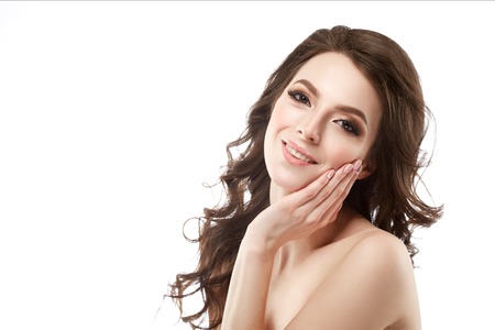 Beautiful woman face portrait with curly flying hair studio on white touching faceの写真素材