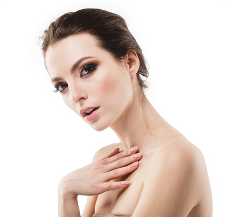 Beautiful woman face neck shoulders is touching her face. close up portrait young studio on whiteの写真素材