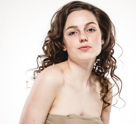 Beautiful woman face with curly flying hair. Studio shot. Isolated on white.の写真素材