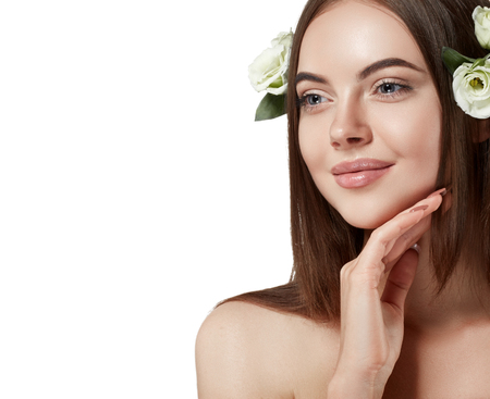 Beautiful woman face close up portrait long beautiful hair with flower young studio on whiteの写真素材
