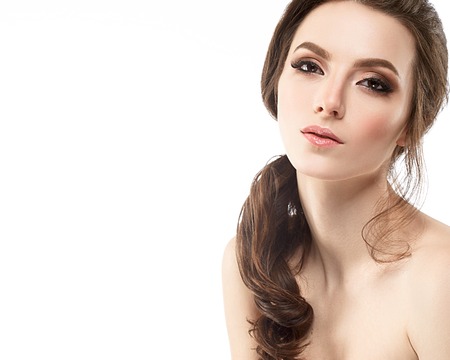 Young beautiful woman face portrait with healthy skin. Studio shot. Isolated on white.の写真素材