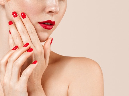 Beautiful woman portrait with perfect make up manicure red lips and nails. Studio shot. Close up view.の写真素材