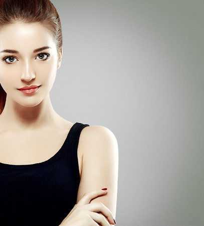 Beautiful woman face close up portrait young. Studio shot. Gray background.の写真素材