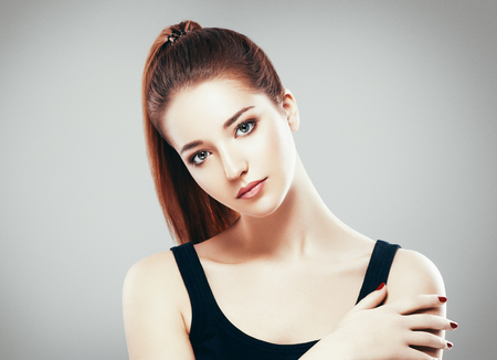 Beautiful woman face close up portrait young. Studio shot. Gray background.の写真素材