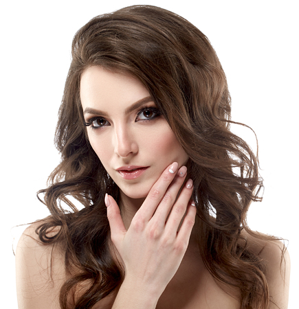 Beautiful woman face portrait with curly flying hair studio on white touching faceの写真素材