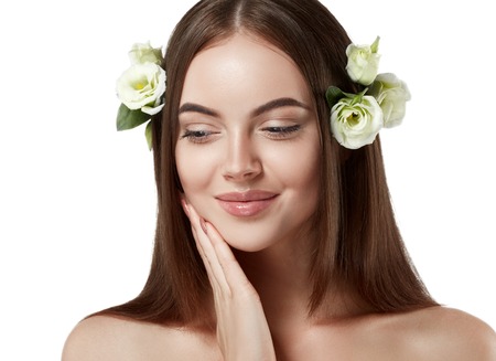 Beautiful woman face close up portrait long beautiful hair with flower young studio on whiteの写真素材