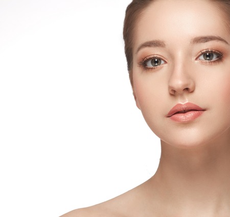 Beautiful woman face close up portrait young. Studio shot. Isolated on white.の写真素材