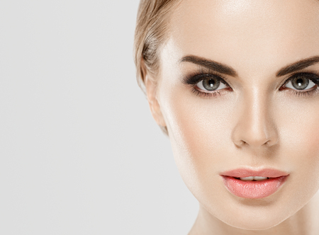 Woman beauty close up eyes lips nose face portrait studio on whiteの写真素材