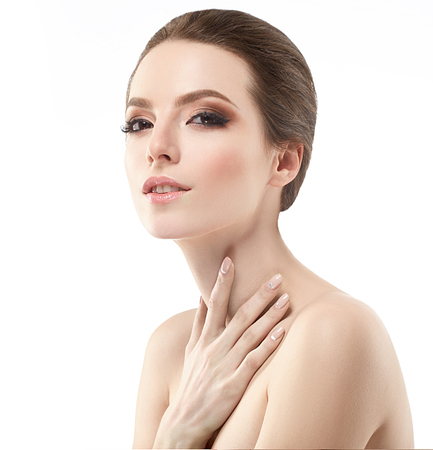 Beautiful woman face neck shoulders is touching her face. close up portrait young studio on whiteの写真素材