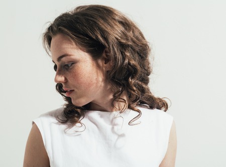 Fashion woman curly hair white dress background freckles happy portraitの写真素材