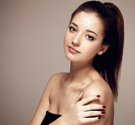 Woman Beauty portrait of attractive female. Skin care, cosmetics and makeup concept.Isolated on brown. Healthy perfect skin.の写真素材