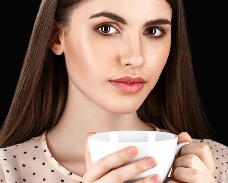 Woman with white cup studio coffee tea. Black background.の写真素材
