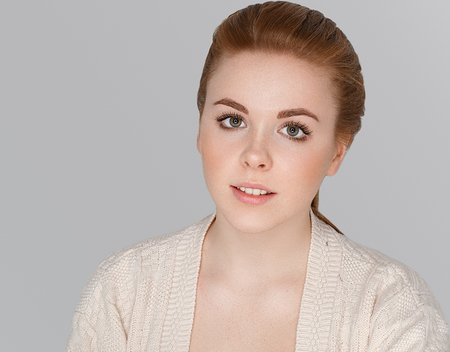 Cute red hair woman portrait.  Studio shot. Gray background.の写真素材