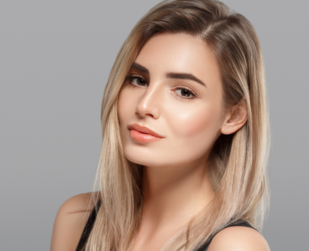 Woman beautiful skin blonde hair portrait close up studio on gray.の写真素材