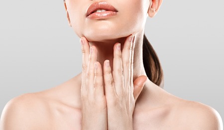 Woman with beautiful neck and shoulders . Studio shot. Gray background.の写真素材