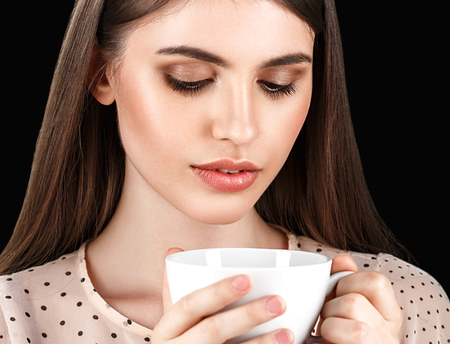 Woman with white cup studio coffee tea. Black background.の写真素材