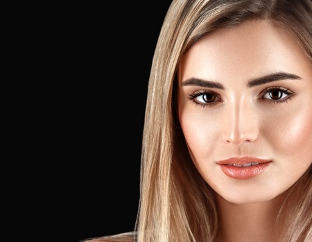 Woman blonde hair closeup beautiful skin portrait on black background.の写真素材