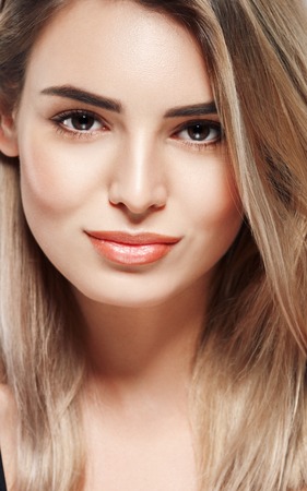 Woman beautiful skin blonde hair portrait close up studio on gray.の写真素材