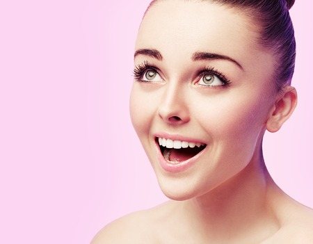 Beautiful fashion woman face close up portrait young studio on pink pin-upの写真素材