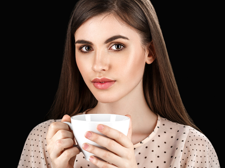 Woman with white cup studio coffee tea. Black background.の写真素材