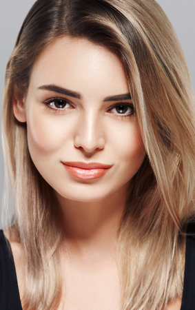 Woman beautiful skin blonde hair portrait close up studio on gray.の写真素材