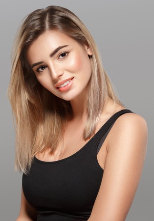 Beautiful woman blonde hair portrait close up studio on gray. Studio shot.の写真素材