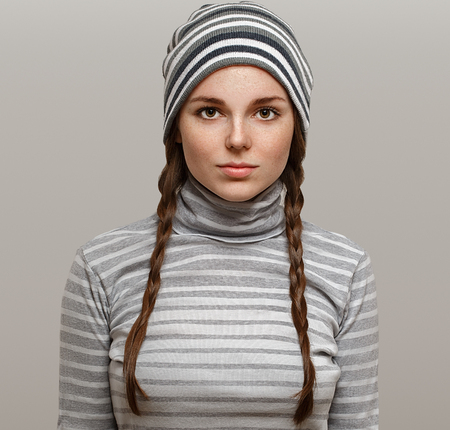 Fashion girl hipster with two long braids. Woman in stripes clothes. Studio shot.の写真素材