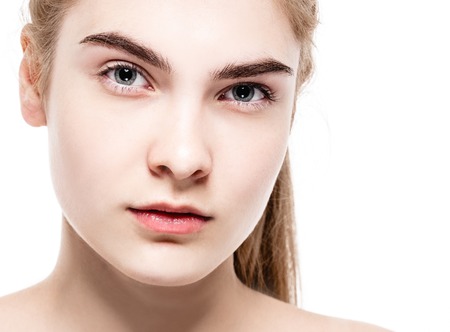 Amazing portrait of a beautiful young woman blond hair with perfect skin closeup. Studio shot. Isolated on white.の写真素材