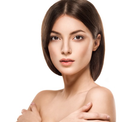 Beauty Woman face Portrait. Beautiful model Girl with Perfect Fresh Clean Skin. Brunette female looking at camera and smiling. Youth and Skin Care Concept. Isolated on a white backgroundの写真素材