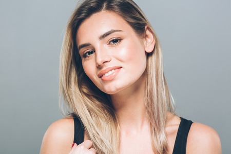 Beautiful young woman portrait smiling posing attractive blond. Studio shot.の写真素材