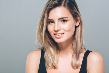 Beautiful young woman portrait smiling posing attractive blond. Studio shot.の写真素材