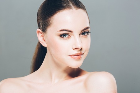 Beautiful woman portrait face. isolated on gray. Studio shot.の写真素材