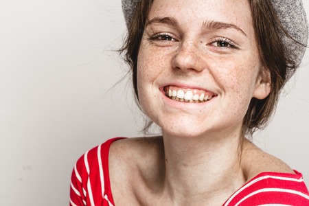 Woman portrait in hat hipster in stripes red clothes happy beautiful. Studio shot.の写真素材