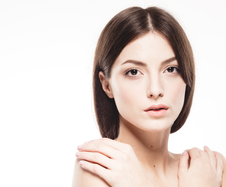 Beauty Woman face Portrait. Beautiful model Girl with Perfect Fresh Clean Skin. Brunette female looking at camera and smiling. Youth and Skin Care Concept. Isolated on a white backgroundの写真素材