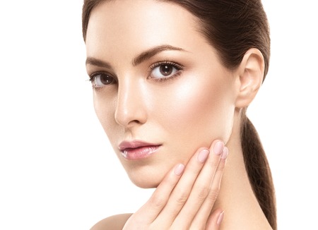 Beauty Woman face Portrait. Beautiful model Girl with Perfect Fresh Clean Skin. Brunette female looking at camera and smiling. Youth and Skin Care Concept. Isolated on a white backgroundの写真素材