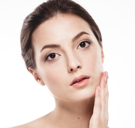 Beauty Woman face Portrait. Beautiful model Girl with Perfect Fresh Clean Skin. Brunette female looking at camera and smiling. Youth and Skin Care Concept. Isolated on a white backgroundの写真素材