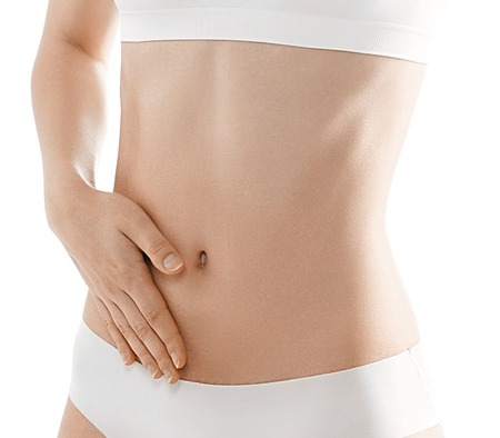 Woman body. Woman hand on a stomach. Studio shot. Isolated on white.の写真素材