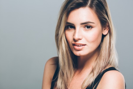 Beautiful young woman portrait smiling posing attractive blond. Studio shot.の写真素材