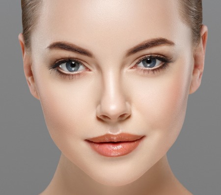 Beautiful woman portrait face. isolated on gray. Studio shot.の写真素材