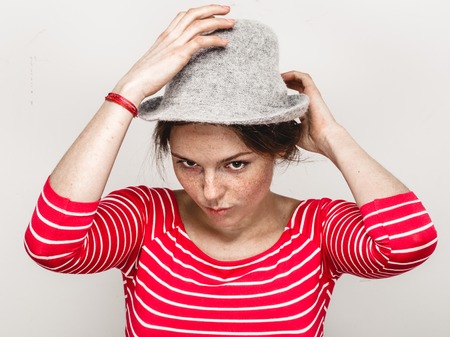Woman portrait in hat hipster in stripes red clothes happy beautiful. Studio shot.の写真素材