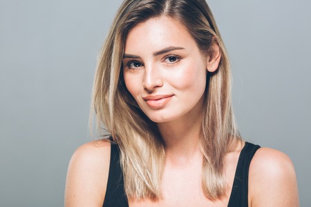 Beautiful young woman portrait smiling posing attractive blond. Studio shot.の写真素材