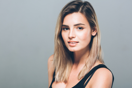 Beautiful young woman portrait smiling posing attractive blond. Studio shot.の写真素材