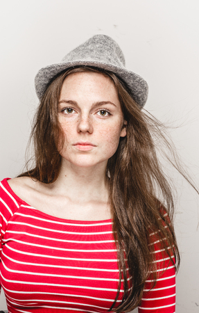 Woman portrait in hat hipster in stripes red clothes happy beautiful. Studio shot.の写真素材