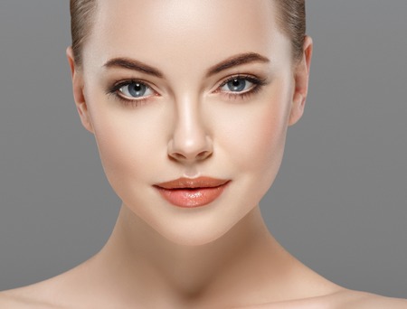 Beautiful woman portrait face. isolated on gray. Studio shot.の写真素材