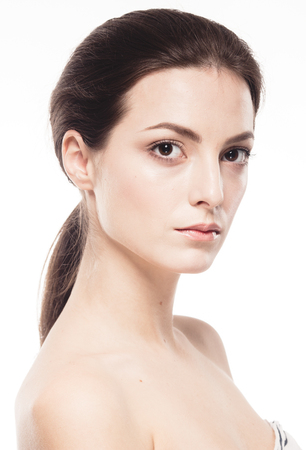 Beauty Woman face Portrait. Beautiful model Girl with Perfect Fresh Clean Skin. Brunette female looking at camera and smiling. Youth and Skin Care Concept. Isolated on a white backgroundの写真素材