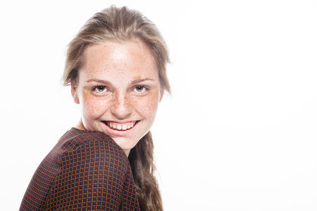 Young beautiful freckles woman face portrait with healthy skin. Studio shot. Isolated on gray.の写真素材