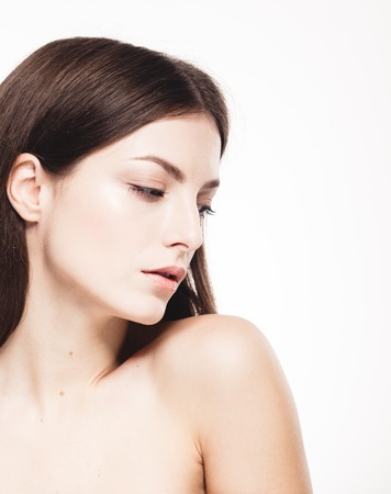 Beauty Woman face Portrait. Beautiful model Girl with Perfect Fresh Clean Skin. Brunette female looking at camera and smiling. Youth and Skin Care Concept. Isolated on a white backgroundの写真素材