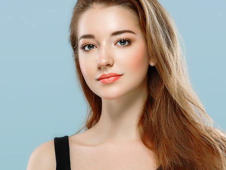 Beautiful woman portrait face on blue background.の写真素材